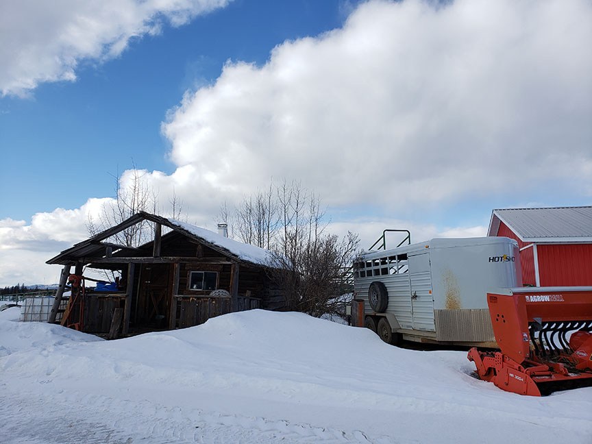 photo of farm equipment and a lean-to shed in the snow