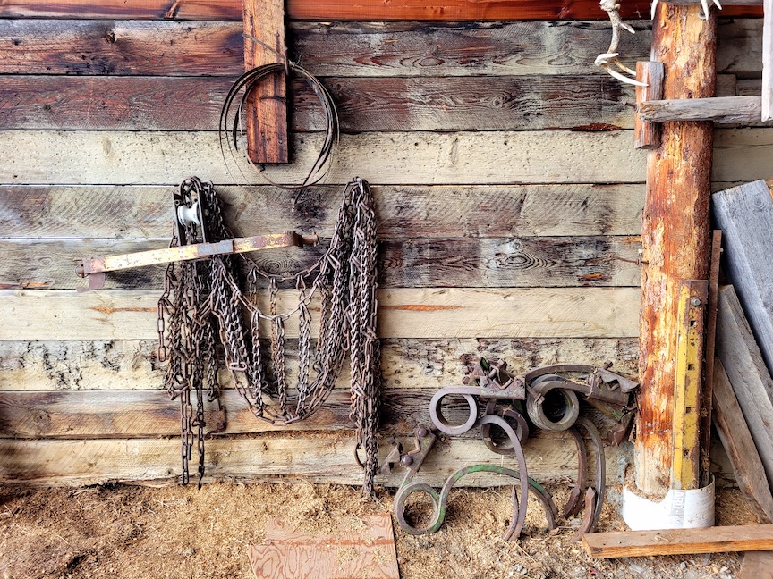 photo of various chains and old tractor parts hanging on a wooden wall