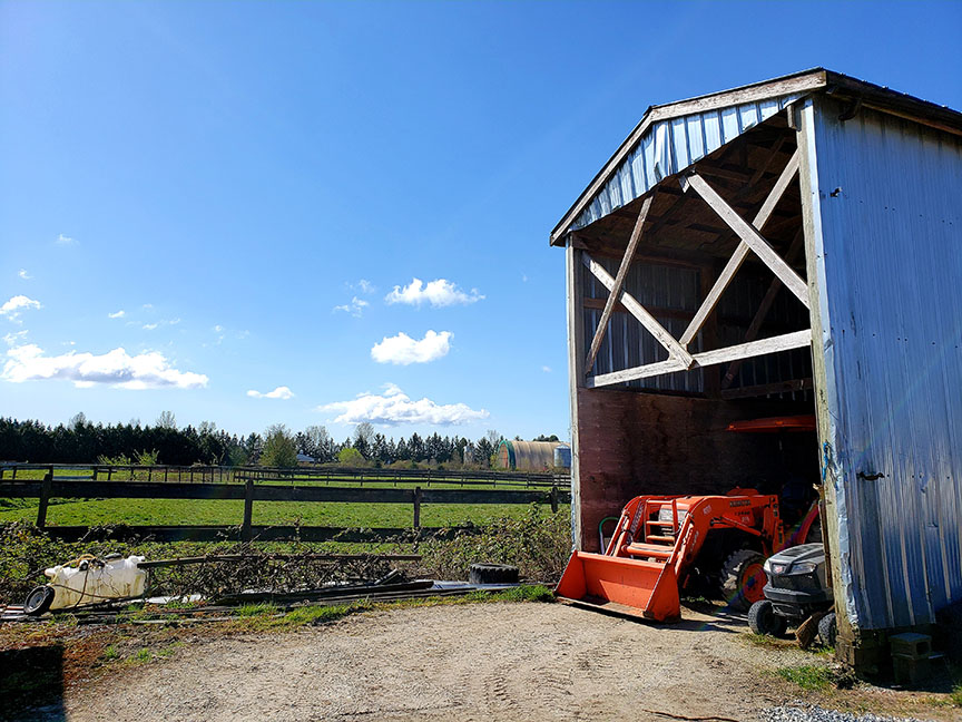 photo of a red tractor, tucked into a large barn