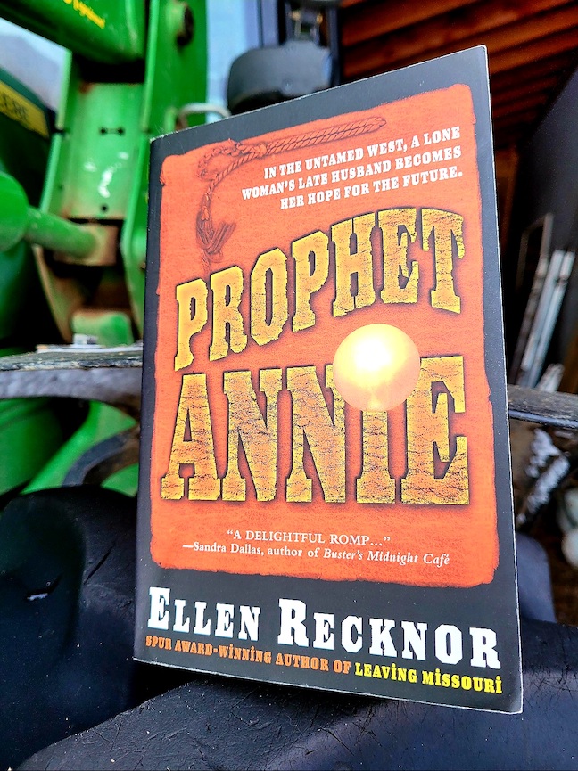 photo of the Prophet Annie book leaning against the top of a John Deer tractor tir