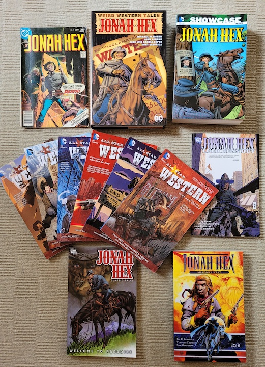 photo of a collection of Jonah Hex comics laid out on a grey carpet
