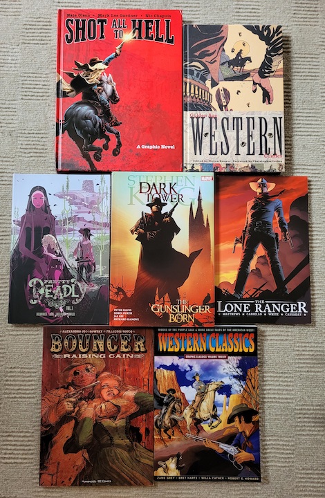 photo of various Western graphic novels laid out on a grey carpet