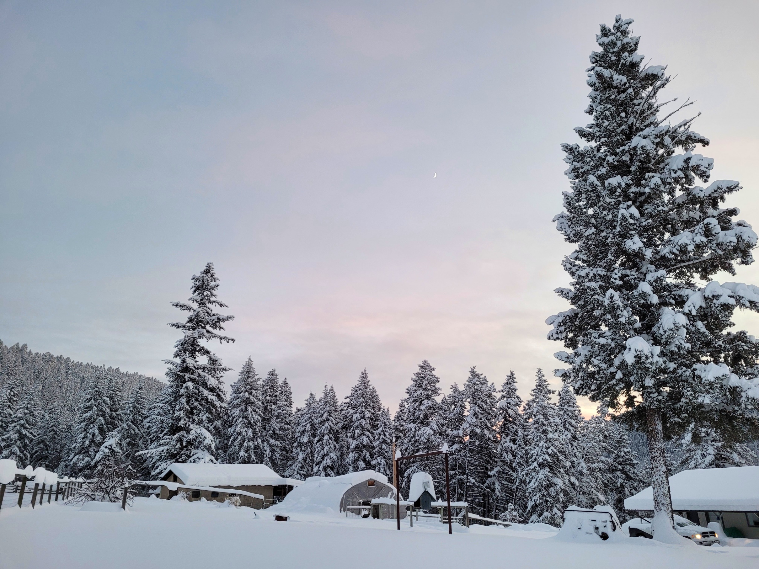 photo of ranch buildings in snow, under the last soft pinks of sunset