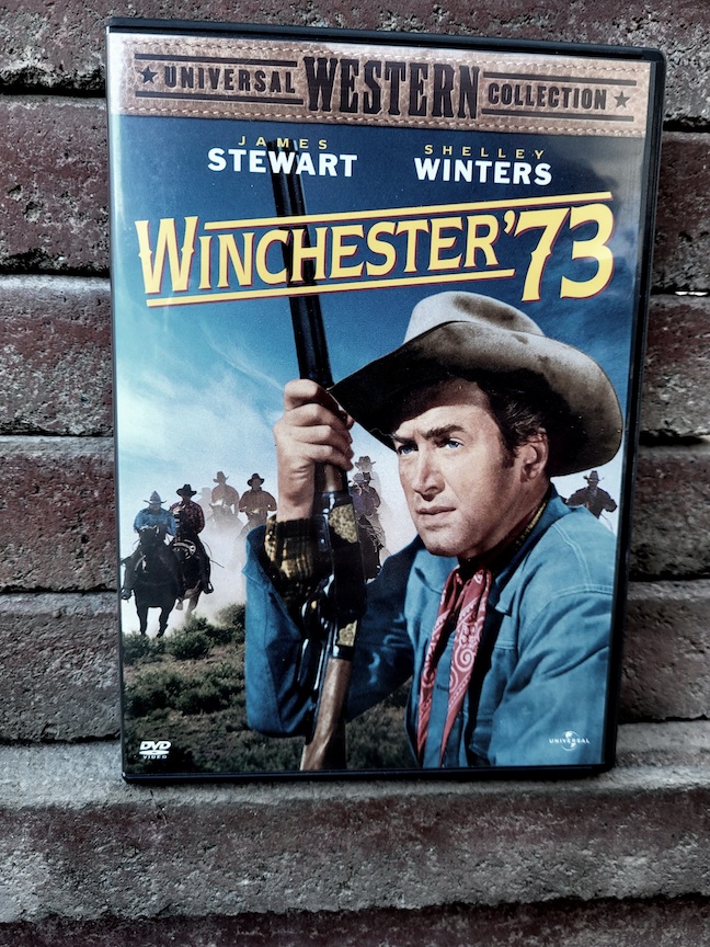 photo of the Winchester 73 DVD against a dark pink stack of brick slabs