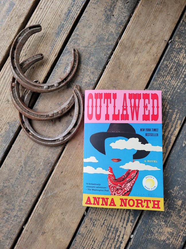 photo of the Outlawed book next to three horseshoes