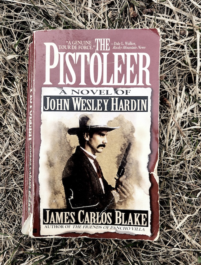 photo of the paperback The Pistoleer against dry, yellow and brown grass