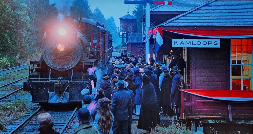 screenshot showing a train pulling out of a crowded station with a sign that reads "Kamloops"