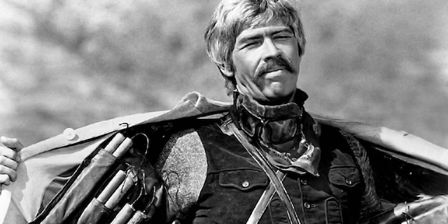 black and white photo of james coburn in duck, you sucker! opening his trenchcoat to show explosives