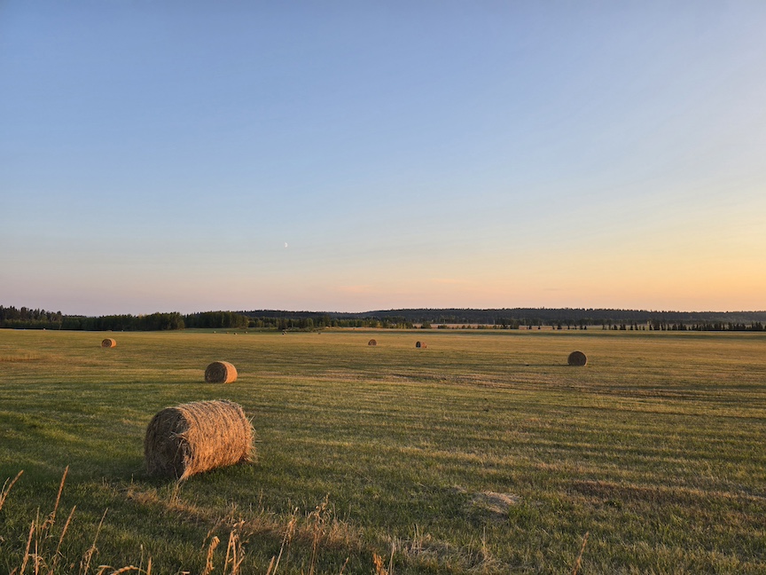 photo of a sunset over hay bales