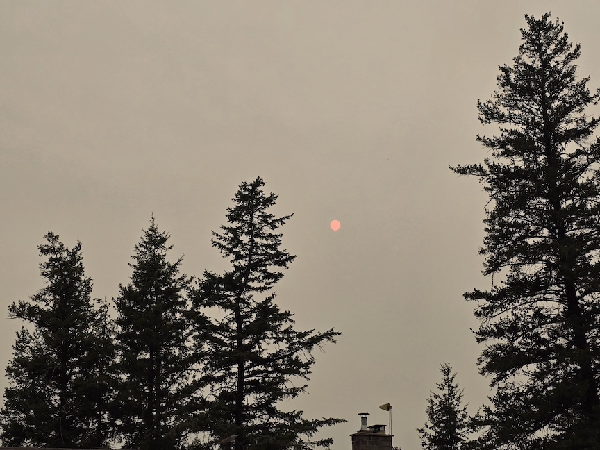photo of a smoke-tinged twilight sky with a red sun