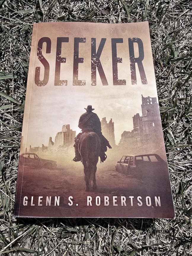 photo of the seeker trade paperback novel against harsh grass